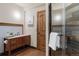 Basement bathroom with wood vanity, corrugated metal, and shower at 556 S Manila Rd, Bennett, CO 80102