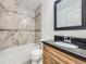 Well-appointed bathroom with tiled walls, a bathtub, and a vanity with dark countertop, offering modern comfort and style at 2830 E 99Th Way, Thornton, CO 80229