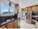 Well-lit kitchen featuring stainless steel appliances, black countertops, and wood cabinets at 2830 E 99Th Way, Thornton, CO 80229