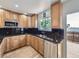 Well-lit kitchen featuring stainless steel appliances, black countertops, and wood cabinets at 2830 E 99Th Way, Thornton, CO 80229