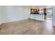 Open-concept living room with wood floors flowing into a modern kitchen, offering a spacious and inviting atmosphere at 2830 E 99Th Way, Thornton, CO 80229