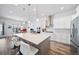 Stylish kitchen featuring a large island with seating, white cabinets, stainless appliances, and pendant lighting at 5925 La Posada Pl, Parker, CO 80134