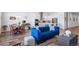Open-concept living room featuring a blue sofa, dining table, and a modern kitchen with stainless steel appliances at 5925 La Posada Pl, Parker, CO 80134