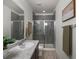 Modern bathroom with gray tiled shower, neutral walls, and wood-look floors at 5347 Warrior St, Frederick, CO 80504