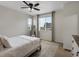 Bedroom featuring windows, ceiling fan, mirror, and a decorative rug at 5347 Warrior St, Frederick, CO 80504