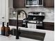 Modern kitchen with stainless steel appliances, dark cabinets, and kitchen sink at 5347 Warrior St, Frederick, CO 80504