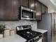 Close-up of kitchen with stainless steel appliances, stove, and dark wood cabinets at 5347 Warrior St, Frederick, CO 80504