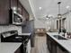 Open kitchen featuring stainless appliances, wood cabinets, and eat-in island open to living area at 5347 Warrior St, Frederick, CO 80504