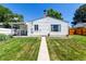 Home exterior with a well-manicured lawn, concrete walkway, and inviting backyard with mature landscaping at 1748 W Tennessee Ave, Denver, CO 80223