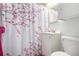Compact bathroom features a cherry blossom shower curtain, vanity and toilet at 1748 W Tennessee Ave, Denver, CO 80223