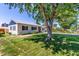 Single-story home with a large shade tree, manicured lawn and black shuttered windows at 1748 W Tennessee Ave, Denver, CO 80223