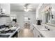 Bright kitchen featuring white cabinets, ceiling fan, and a view into the dining area at 1748 W Tennessee Ave, Denver, CO 80223