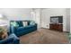 Comfortable living room with a plush blue sofa, vintage furniture, and neutral carpeting at 1748 W Tennessee Ave, Denver, CO 80223