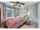Bright bedroom with a comfortable queen bed, a ceiling fan, and a large window offering natural light at 467 S Reed Ct, Lakewood, CO 80226