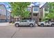 Modern townhome with brick and siding, featuring a balcony and tree-lined street at 467 S Reed Ct, Lakewood, CO 80226
