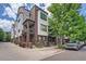 Charming townhome with brick and siding exterior, small porch, and mature landscaping at 467 S Reed Ct, Lakewood, CO 80226
