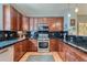Well-equipped kitchen with dark wood cabinets, granite countertops, and stainless steel appliances at 467 S Reed Ct, Lakewood, CO 80226