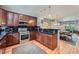 Open kitchen with wood cabinets and stainless steel appliances adjoining the dining and living areas at 467 S Reed Ct, Lakewood, CO 80226