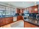 Well-lit kitchen featuring wood cabinets, stainless steel appliances, and black granite countertops at 467 S Reed Ct, Lakewood, CO 80226