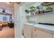Practical laundry area equipped with appliances, storage shelves, and a view into adjacent living room at 467 S Reed Ct, Lakewood, CO 80226