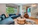 Bright living room featuring a large window, blue sectional sofa, and hardwood floors at 467 S Reed Ct, Lakewood, CO 80226