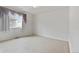 Bright bedroom featuring neutral carpet, a window with curtains, and freshly painted white walls at 11237 W 55Th Ln, Arvada, CO 80002