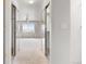 Hallway featuring mirrored sliding doors, a ceiling fan, and a view into the bedroom at 11237 W 55Th Ln, Arvada, CO 80002