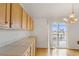 Bright kitchen features tile countertops, wood cabinets, and a sliding glass door to a deck at 11237 W 55Th Ln, Arvada, CO 80002