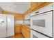 Bright kitchen featuring white appliances, hardwood floors, and light wood cabinets offering ample storage space at 11237 W 55Th Ln, Arvada, CO 80002