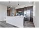 Open concept kitchen with quartz countertops, stainless steel appliances, and gray wood flooring at 1208 N Quitman St # 402, Denver, CO 80204
