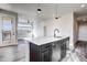 Open concept kitchen with quartz countertops, stainless steel appliances, and gray wood flooring at 1208 N Quitman St # 402, Denver, CO 80204