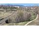 Picturesque park view with walking trails, lush trees, bridges, and mountains in the background at 1208 N Quitman St # 402, Denver, CO 80204