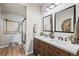 Stylish bathroom features a double vanity, quartz countertop, wood-look floors, and a walk-in shower at 16231 Thunder Cat Way, Monument, CO 80132