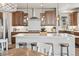 Kitchen island with pendant lighting, light countertops, stainless appliances, and dark wood cabinets at 16231 Thunder Cat Way, Monument, CO 80132