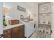 Bright laundry room features ample counter space, wooden cabinets, shelving, and stylish decor at 16231 Thunder Cat Way, Monument, CO 80132
