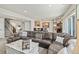 Open-concept living room features a large leather sofa and a stylish wet bar with pendant lighting at 16231 Thunder Cat Way, Monument, CO 80132