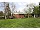 Well-maintained backyard featuring a classic brick home and a lush green lawn, perfect for outdoor activities at 1908 Taft Dr, Lakewood, CO 80215