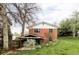 Brick home exterior with a covered patio and lush green backyard at 1908 Taft Dr, Lakewood, CO 80215