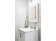 Bathroom vanity with a white cabinet, marble countertop, modern faucet, and framed mirror at 1908 Taft Dr, Lakewood, CO 80215