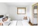 Bright bedroom with a bed, decorative pillows, two windows, and a sitting chair at 1908 Taft Dr, Lakewood, CO 80215