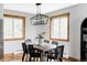 Dining room featuring a wooden table, six chairs, and natural light from wood-trimmed windows at 1908 Taft Dr, Lakewood, CO 80215