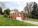 Charming brick home on a sloped lot, features an attached garage and inviting curb appeal at 1908 Taft Dr, Lakewood, CO 80215