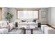 Cozy living room featuring large windows, comfortable seating, and a decorative rug on hardwood floors at 1908 Taft Dr, Lakewood, CO 80215