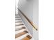View of the white stairs with wooden treads and a wooden handrail against a gray wall at 1908 Taft Dr, Lakewood, CO 80215