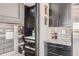 Modern kitchen showcasing pantry, built-in microwave, black cabinetry, and sleek countertops, enhancing functionality at 1655 Wolff St, Denver, CO 80204
