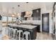 Modern kitchen featuring dark cabinets, marble countertops, stainless steel appliances, and a large island at 1655 Wolff St, Denver, CO 80204
