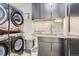 Well-equipped laundry room with modern appliances, countertop, and ample storage at 1655 Wolff St, Denver, CO 80204