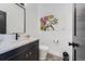 Modern powder room with black vanity, stylish mirror, toilet, and trendy art at 1655 Wolff St, Denver, CO 80204
