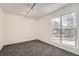 Bright bedroom with grey carpet and large window offering natural light at 16046 E Harvard Ave, Aurora, CO 80013