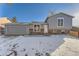 Charming two-story home with gray siding, brick foundation, and a snowy front yard at 16046 E Harvard Ave, Aurora, CO 80013